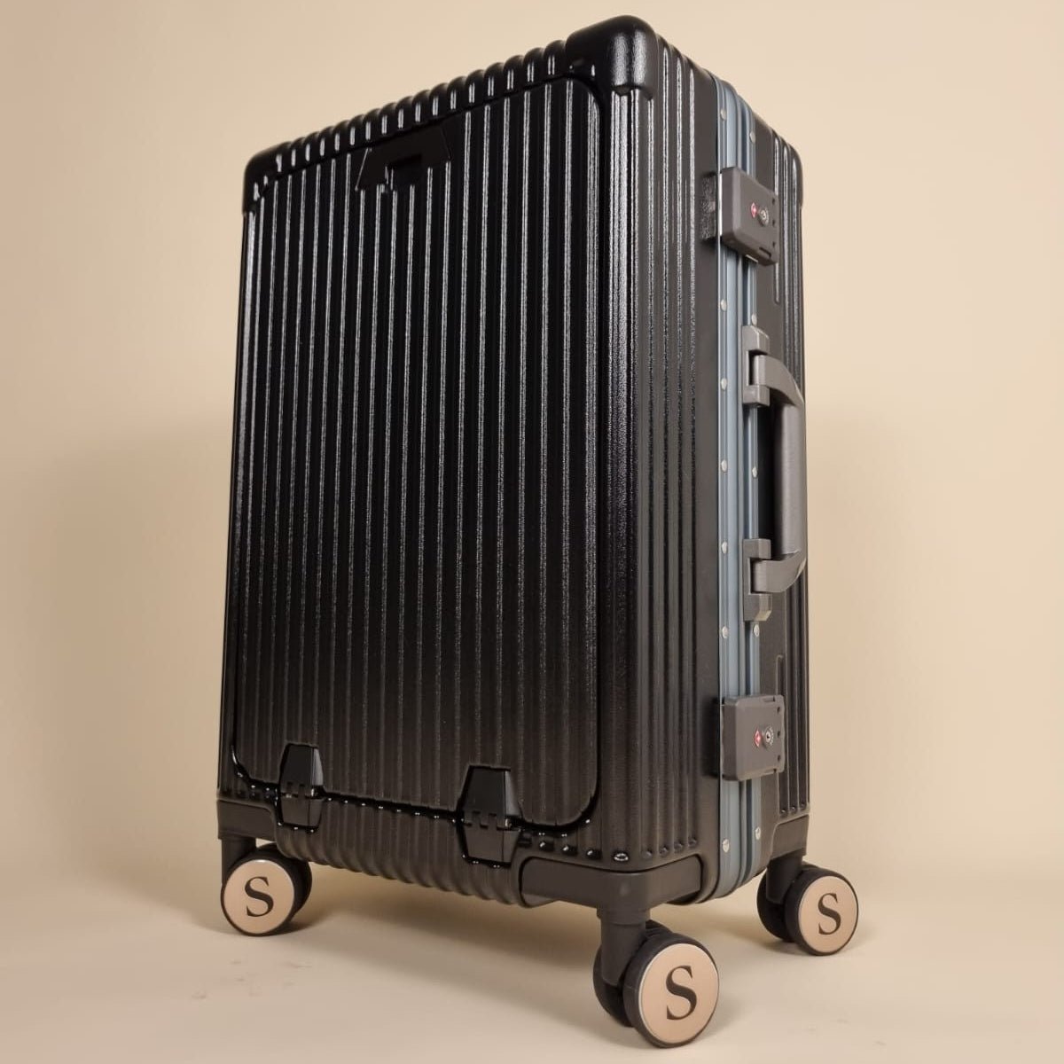 Valise cabine aluminium haut de gamme Maison Solen, coque noire rainurée avec design sans fermeture éclair.