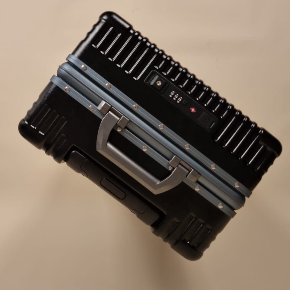 Valise aluminium noire Maison Solen vue de dessus, poignée robuste et double cadenas TSA intégrés.